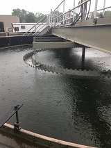 Wastewater treatment plant clarifier in operation.