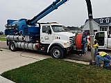 Vacuum truck and workers at a residential site.