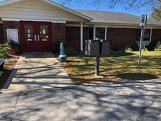 Accessible entrance with ramp and handrail to building.