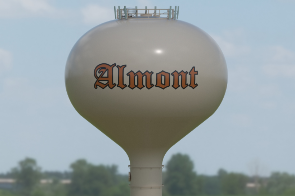 Almont water tower against a clear blue sky.